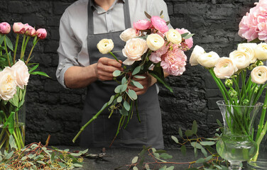Mannelijke bloemist die een mooi boeket maakt in de bloemenwinkel, close-up