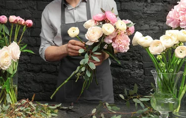 Fototapete Blumenladen Männlicher Florist, der einen schönen Blumenstrauß im Blumenladen kreiert, Nahaufnahme