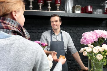Crédence de cuisine en verre imprimé Fleuriste Fleuriste recevant une carte de réduction d& 39 un client régulier dans un magasin de fleurs