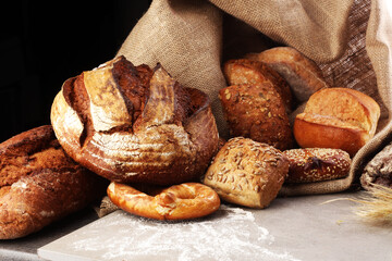 freshly baked bread. Different kinds of bread and bread rolls on board from above. Kitchen or bakery poster design.