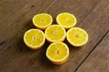 Fototapeta na wymiar Yellow Fresh Lemon Slice Over Wooden Background