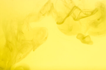 Yellow acrylic color. Ink swirling in water. Color explosion