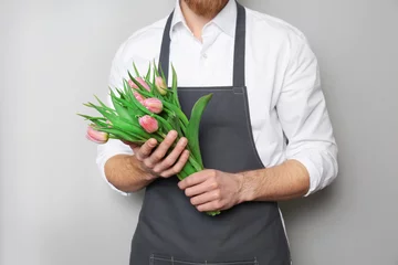 Crédence de cuisine en verre imprimé Fleuriste Young florist with beautiful tulips on grey background