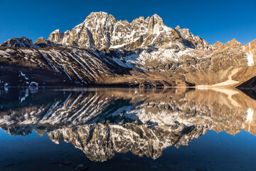 Sunrise over Pharilapche peak which is reflecting in a Gokyo Lake in a cloudless weather. Sagarmatha National Park, Solukhumbu District in Nepal, Asia. 