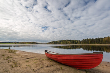 Fototapeta na wymiar Red boat on the lake shore, Finland