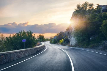 Foto op Aluminium Mountain road. Landscape with rocks, sunny sky with clouds and beautiful asphalt road in the evening in summer. Vintage toning. Travel background. Highway in mountains. Transportation © den-belitsky