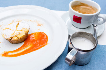 Viennese Apple strudel with fruit sauce on a plate. not a classic shape in a unique way. a Cup of coffee and a warm frothed milk