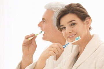 Senior couple cleaning teeth at home