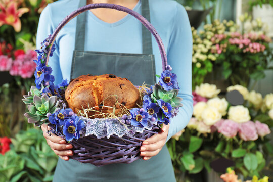 Woman holding Easter wicker basket with traditional cake