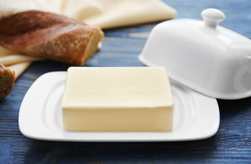 Dish with butter on wooden table