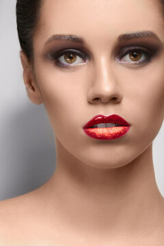 Beautiful young woman with creative makeup on light background, closeup