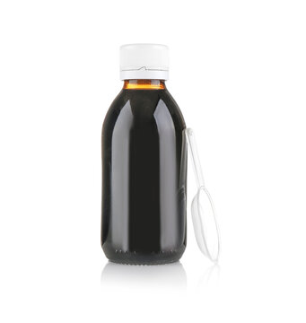 Bottle with cough syrup and measuring spoon on white background