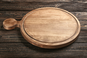 Round cutting board on wooden background