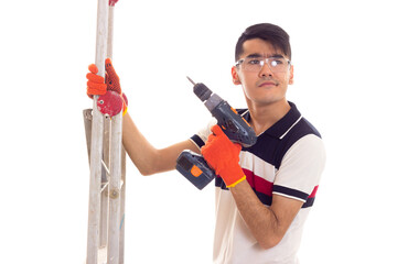 Young man holding ledder and electric screwdriver 