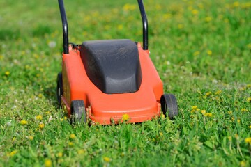 Orange Lawn mower cutting grass