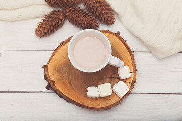 Cup with hot chocolate and marshmallows on a wooden tray