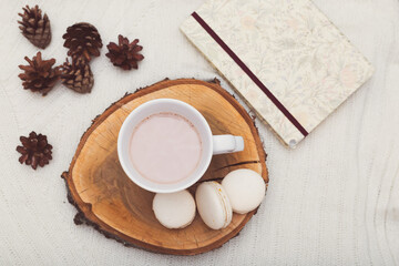 hygge. A cup of cocoa stands on a wooden tray, beside lie cones