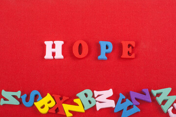 HOPE word on red background composed from colorful abc alphabet block wooden letters, copy space for ad text. Learning english concept.