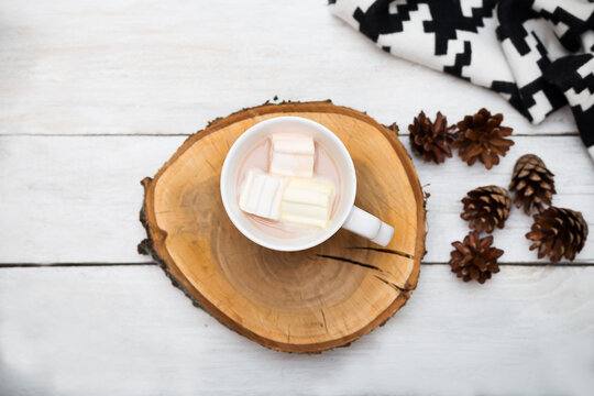 White cup with hot chocolate and marshmallows on a white wooden background. flat lay