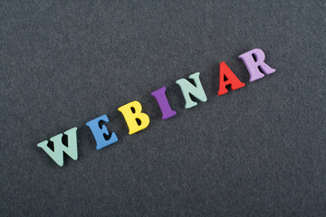 WEBINAR word on black board background composed from colorful abc alphabet block wooden letters, copy space for ad text. Learning english concept.