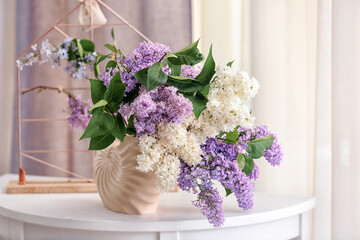 Ceramic vase with beautiful lilac flowers on wooden table