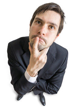 Young man is thinking and looking at you. View from above. Isolated on white background.