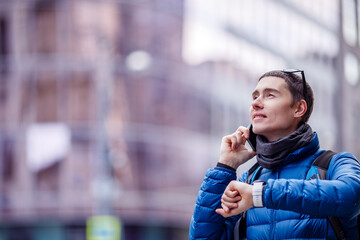 Man talking on phone and looking at smartwatch