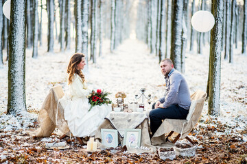 Winter wedding newlyweds sitting at a decorated table in rustic style