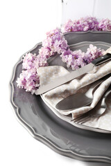 Beautiful festive table setting with lilac flower decor on white background, closeup