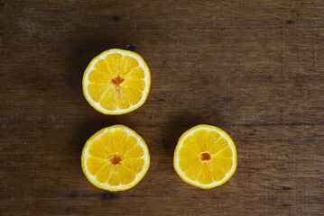 Naklejka na ściany i meble Yellow Fresh Lemon Slice Over Wooden Background