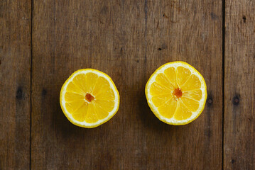 Fototapeta na wymiar Yellow Fresh Lemon Slice Over Wooden Background