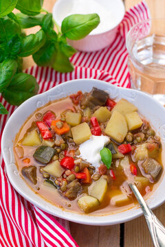 Lentil soup with summer vegetables and sour cream
