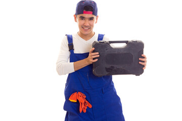 Young man in overall holding toolbox