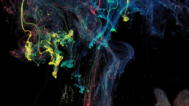 Colorful rainbow paint drops from mixing in water. Ink swirling underwater. Cloud of ink isolated on black background. Colored abstract smoke explosion animation effect. Close up view