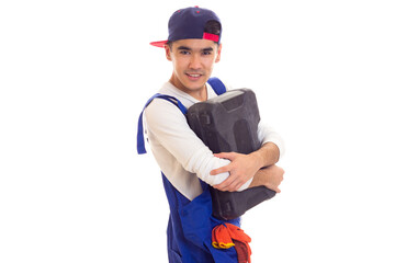 Young man in overall holding toolbox