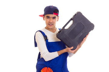 Young man in overall holding toolbox