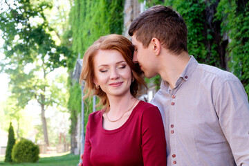 Fototapeta premium young man hugging pretty young redhead woman