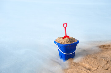 Beach bucket in sand