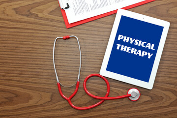 Red stethoscope with tablet on wooden table