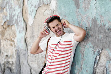 Handsome man with headphones listening music on street