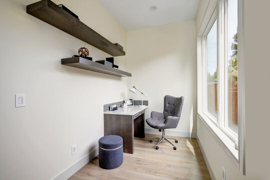 Light small home office interior with corner desk and a chair