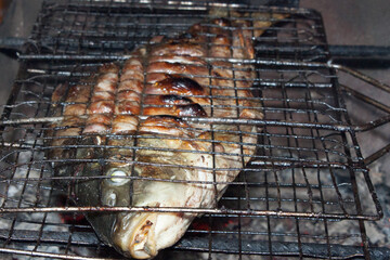Fried fish carp on charcoal grilles