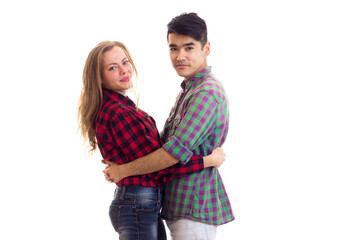 Young couple in plaid shirts hugging