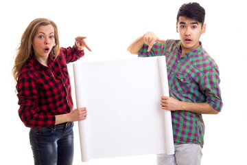 Young couple in plaid shirts holding placard