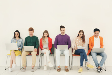 Young people with gadgets sitting on chairs