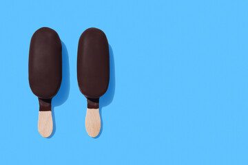 Dark chocolate ice-cream bars on bright blue background