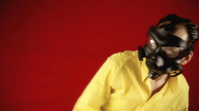 A man wearing a scary ugly gas mask running away from a danger and falling down like he's been hit by a shockwave. Comic cartoonish scene.
