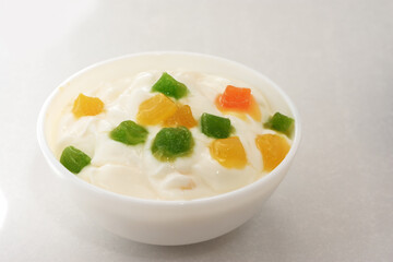  Yogurt with slices of fruit and candied fruits on a white background