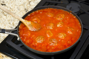 Cooking marinara and meatballs