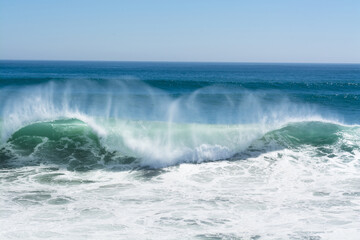 Wave crest breaking along beach